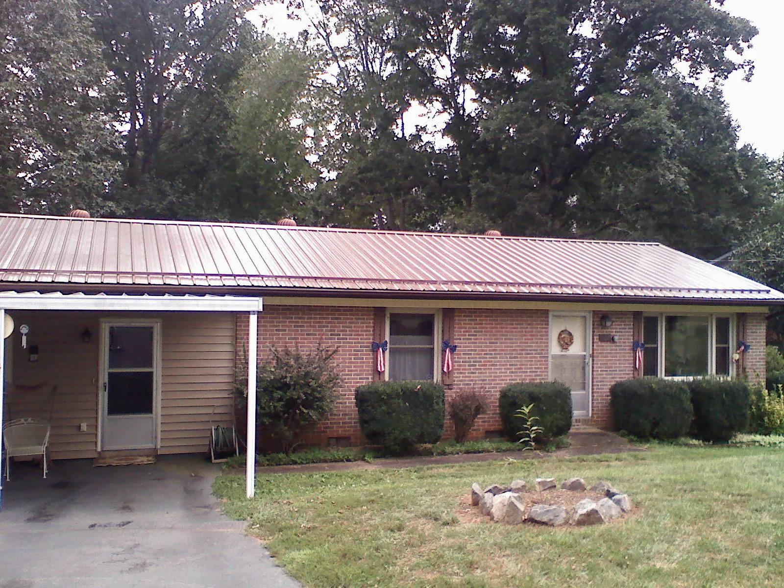 Bronze metal roof and carport on a brick ranch home — Roof Repair work by our crew in Gordonsville